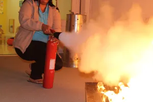 Personne utilisant un extincteur sur un incendie