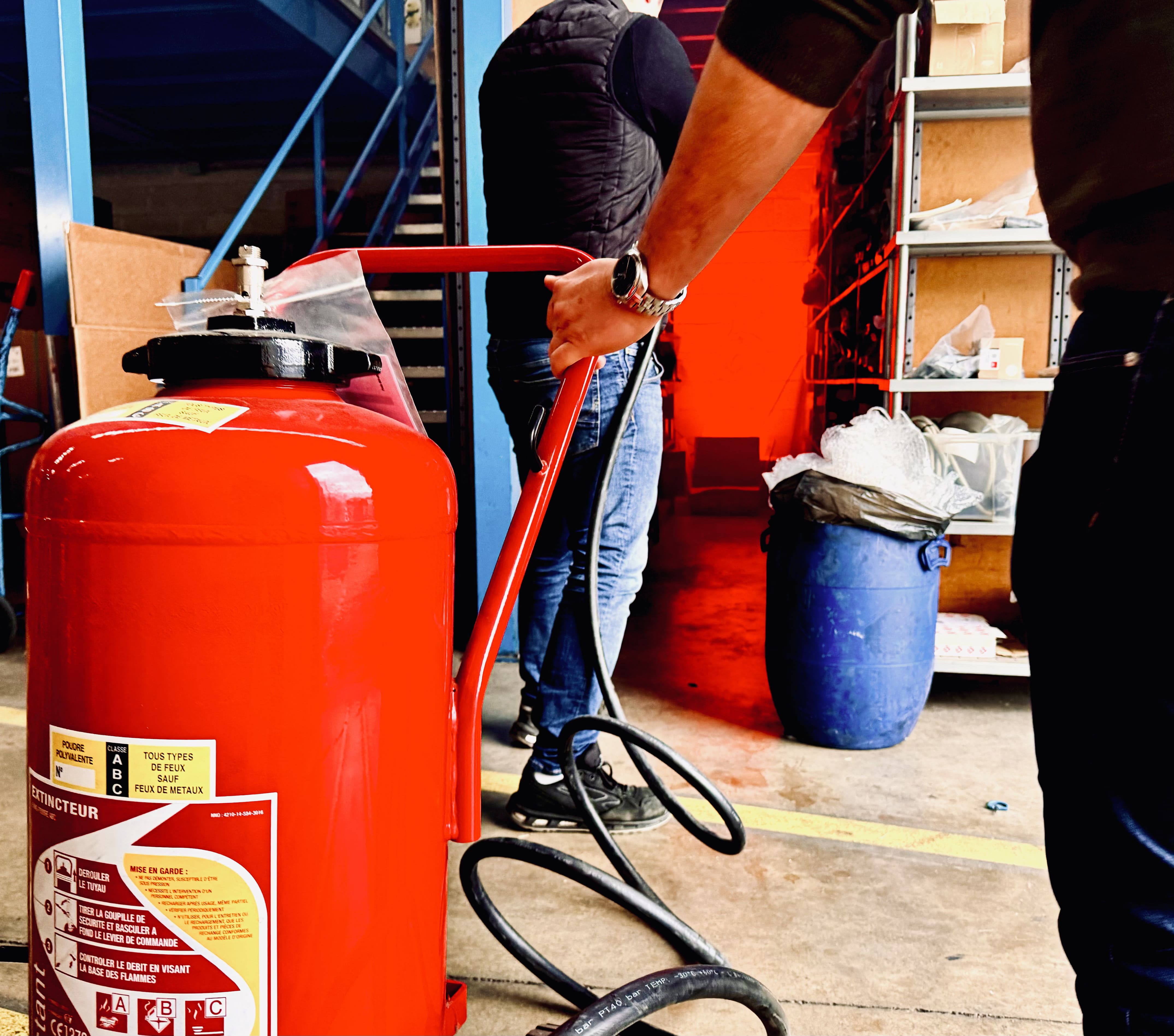 Un extincteur rouge utilisé lors d'une formation incendie.