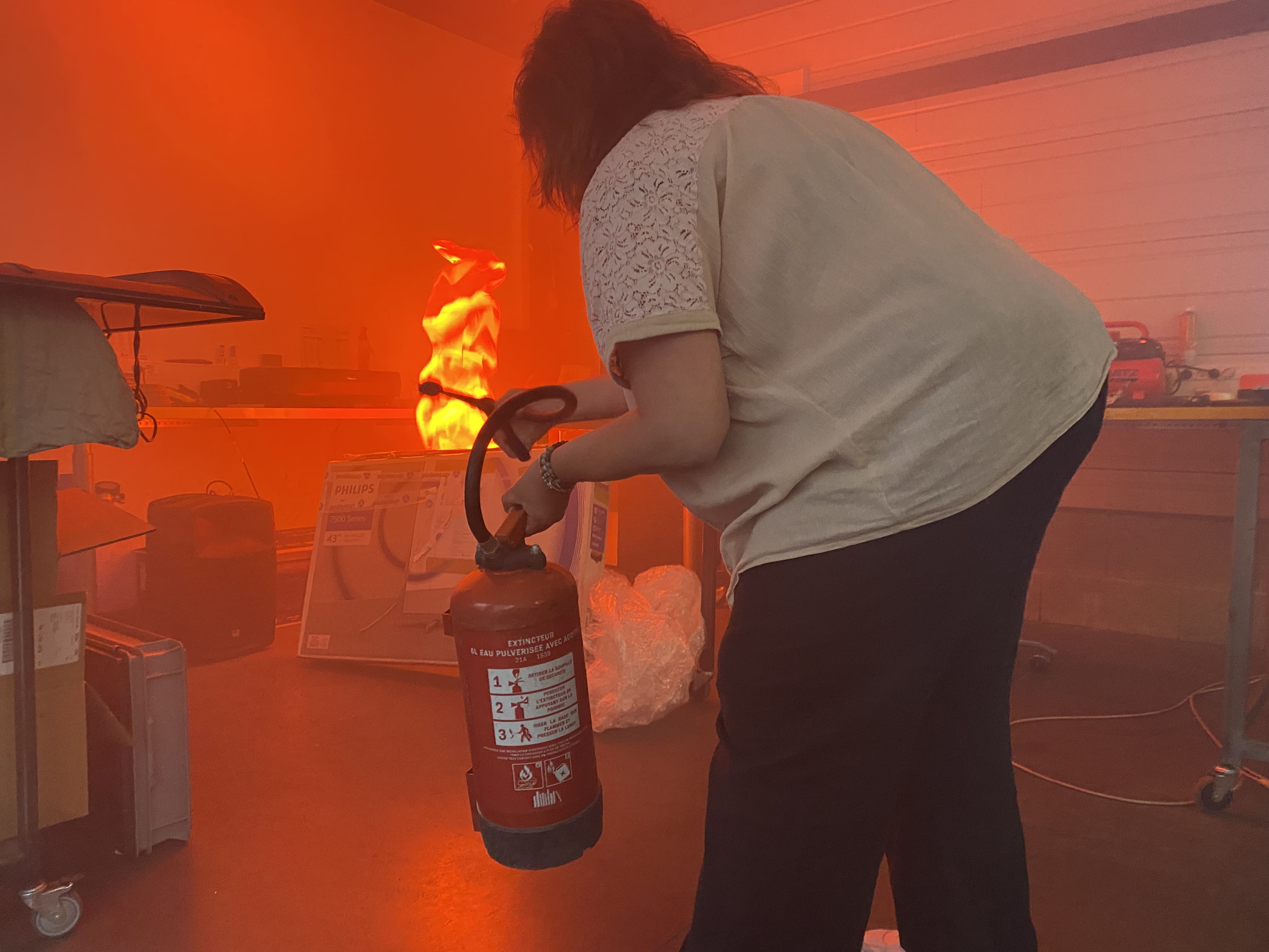 Personne utilisant un extincteur dans une salle enfumée
