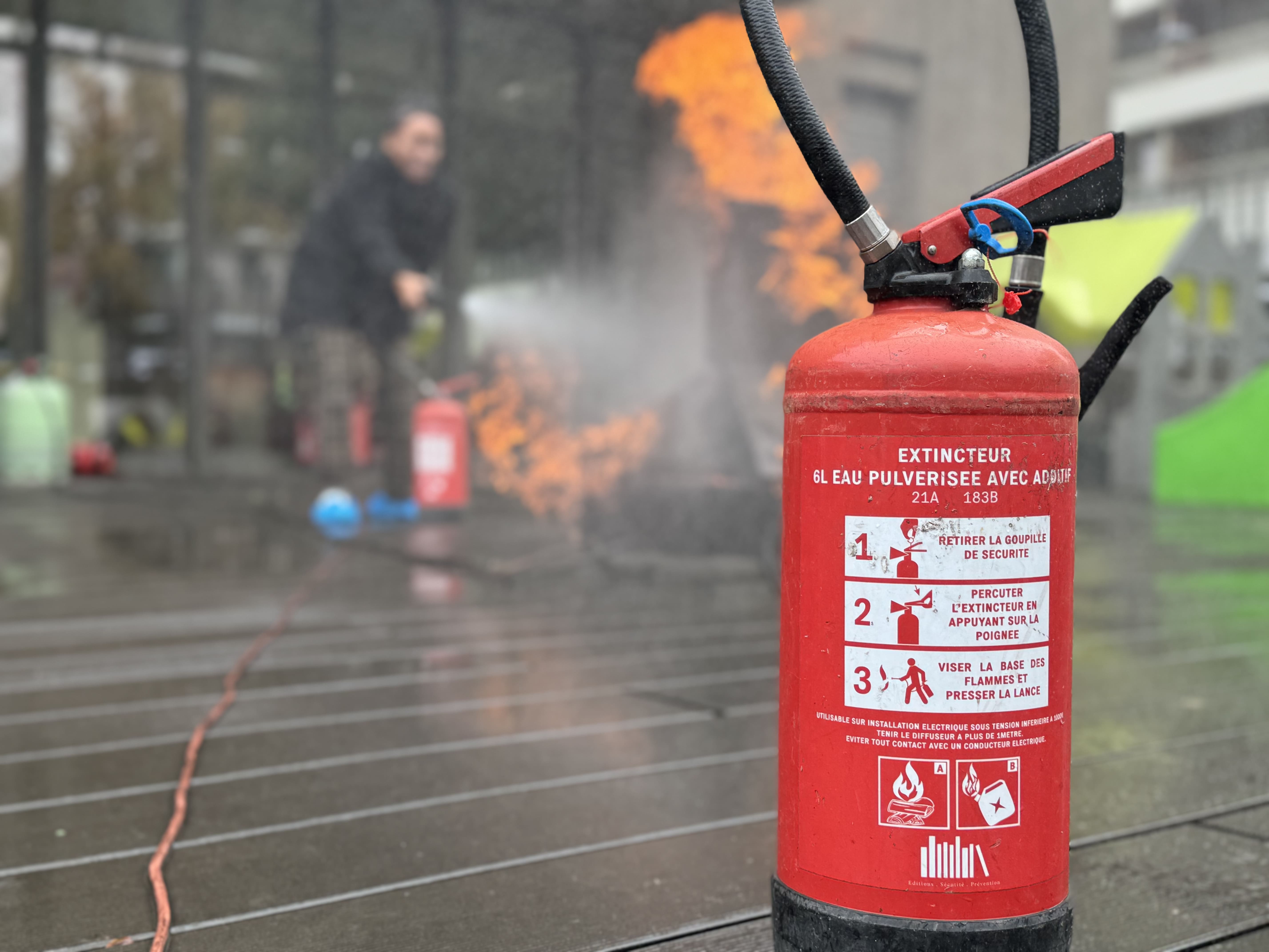 Un extincteur face à un feu lors d'une formation incendie.